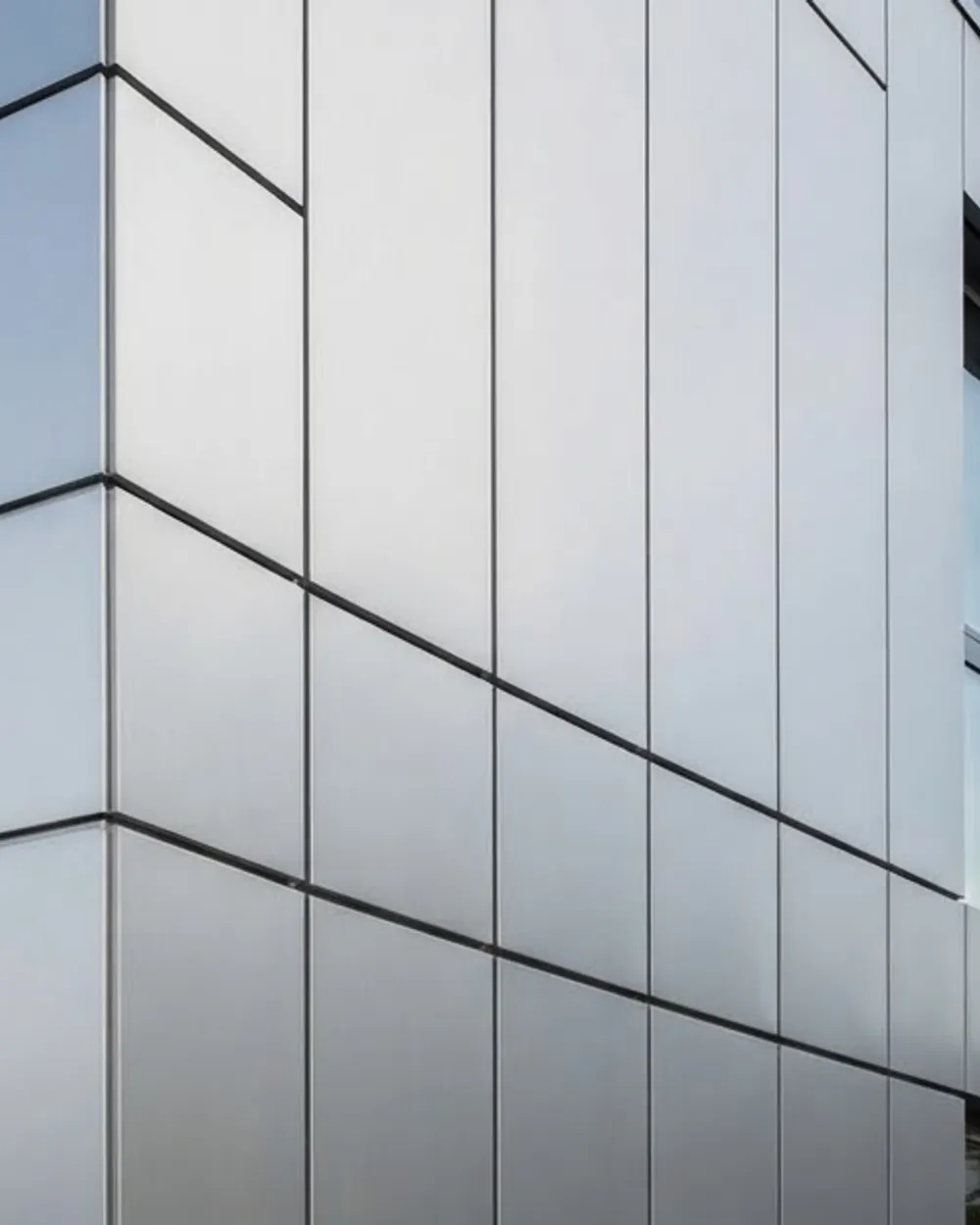 Aluminium composite cladding panels running across an elevation with square, even joints.
